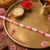 Pink & White Thread Rakhi – Elegant Traditional Beaded Design